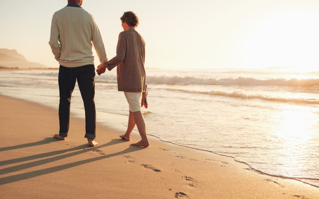 Couple walking on the beach in retirement